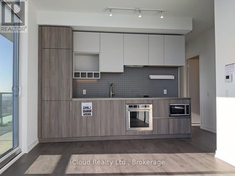 A modern kitchen with wooden cabinets and a tiled backsplash.