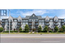 A large, modern apartment building with multiple balconies and a well-maintained lawn in front.