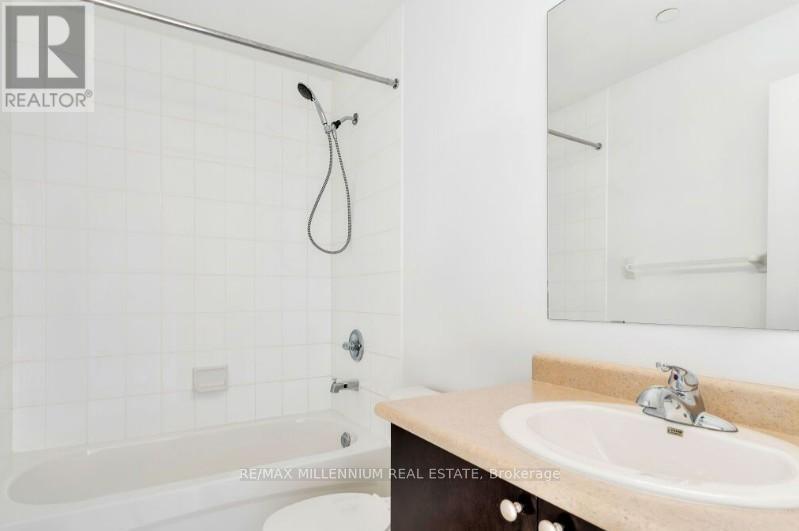A white bathroom with a tub, sink and mirror.
