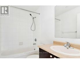A white bathroom with a tub, sink and mirror.