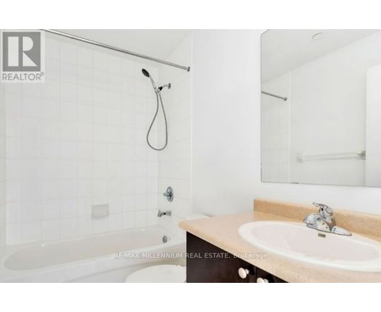 A white bathroom with a tub, sink and mirror.
