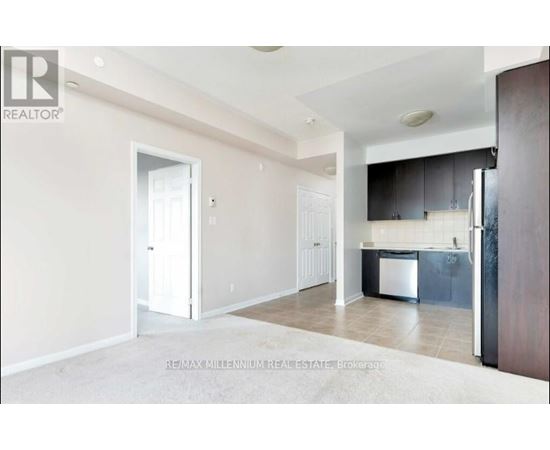 A real estate listing photo of a kitchen and living room.