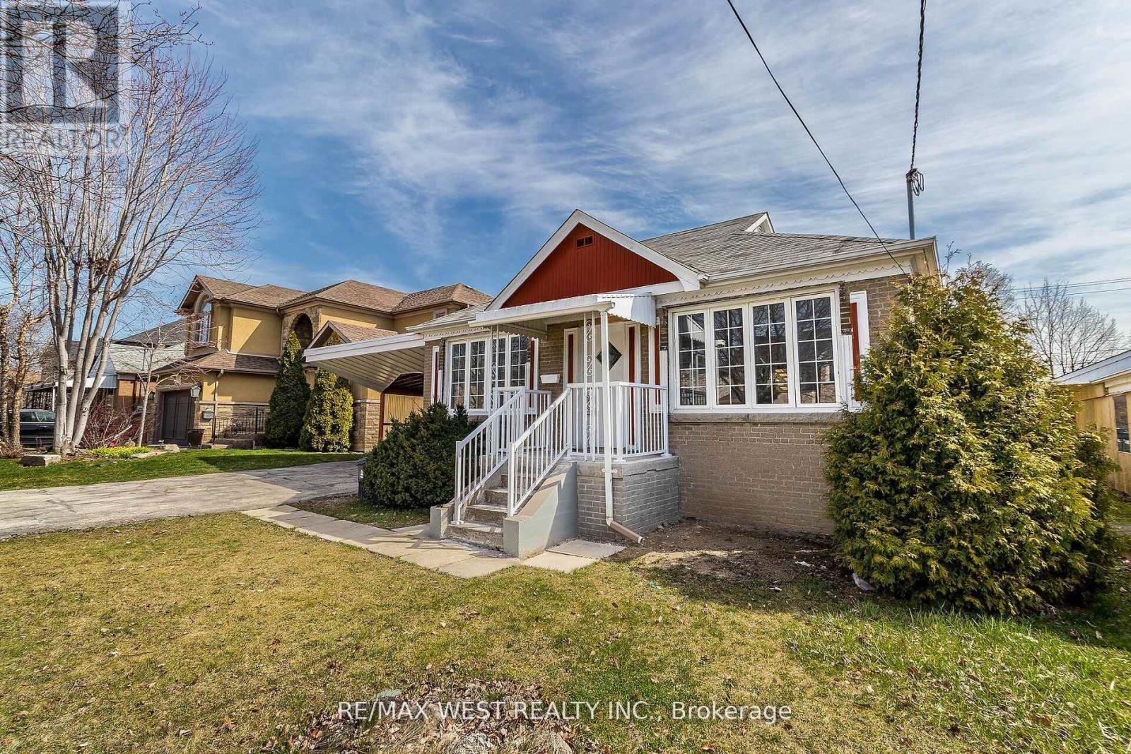 A house with a red roof and a white fence is for sale.