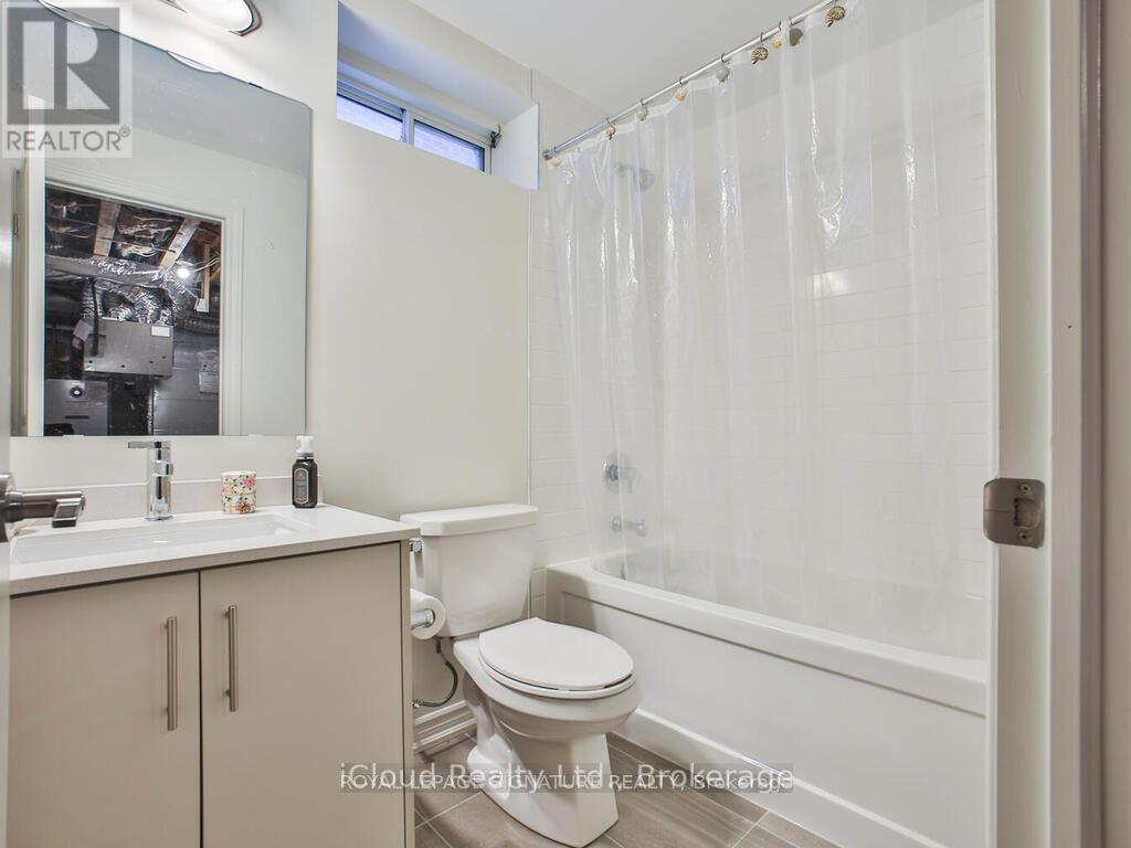 A white bathroom with a toilet, sink, and shower.