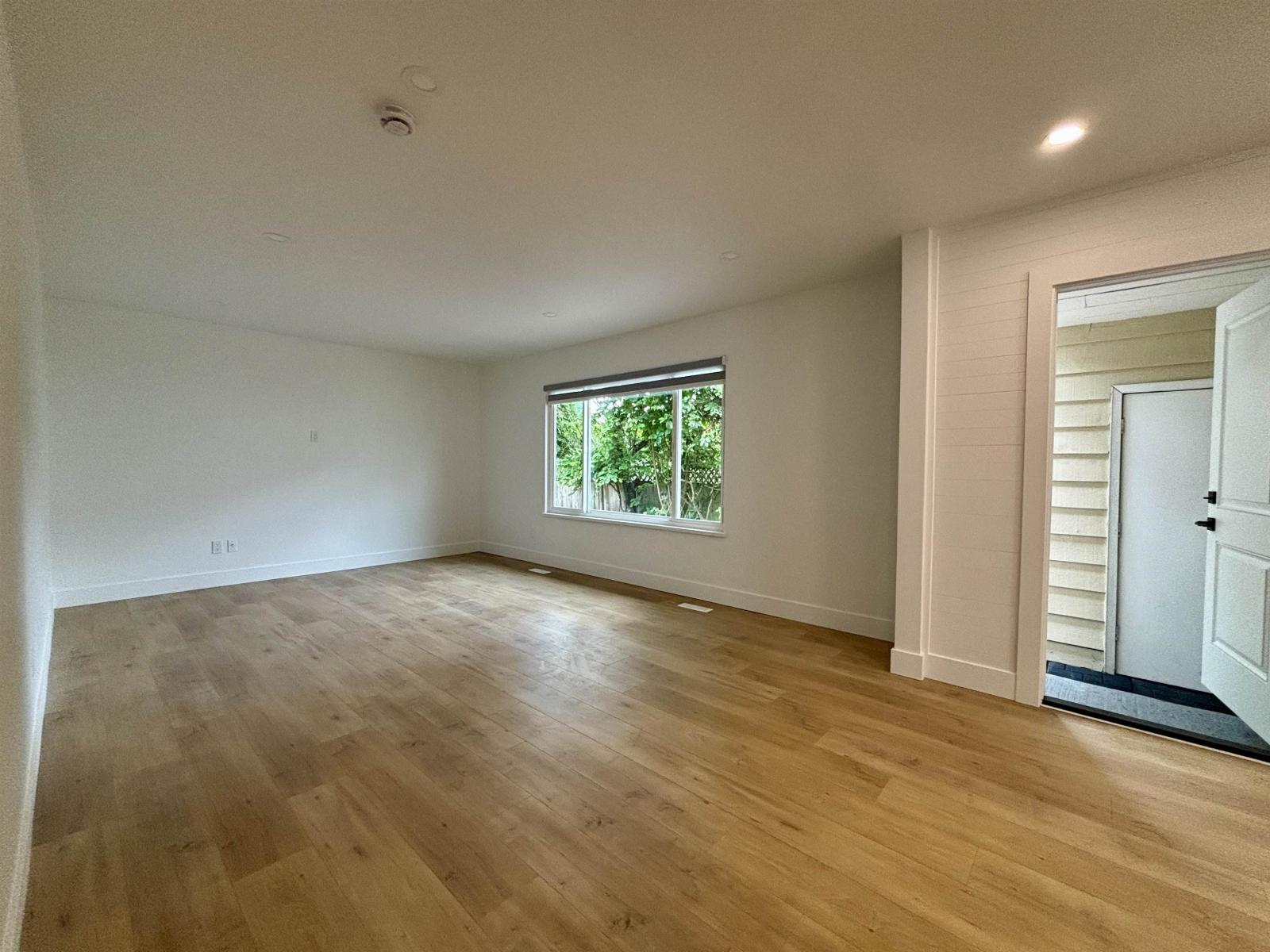 A room with wooden flooring and a window.