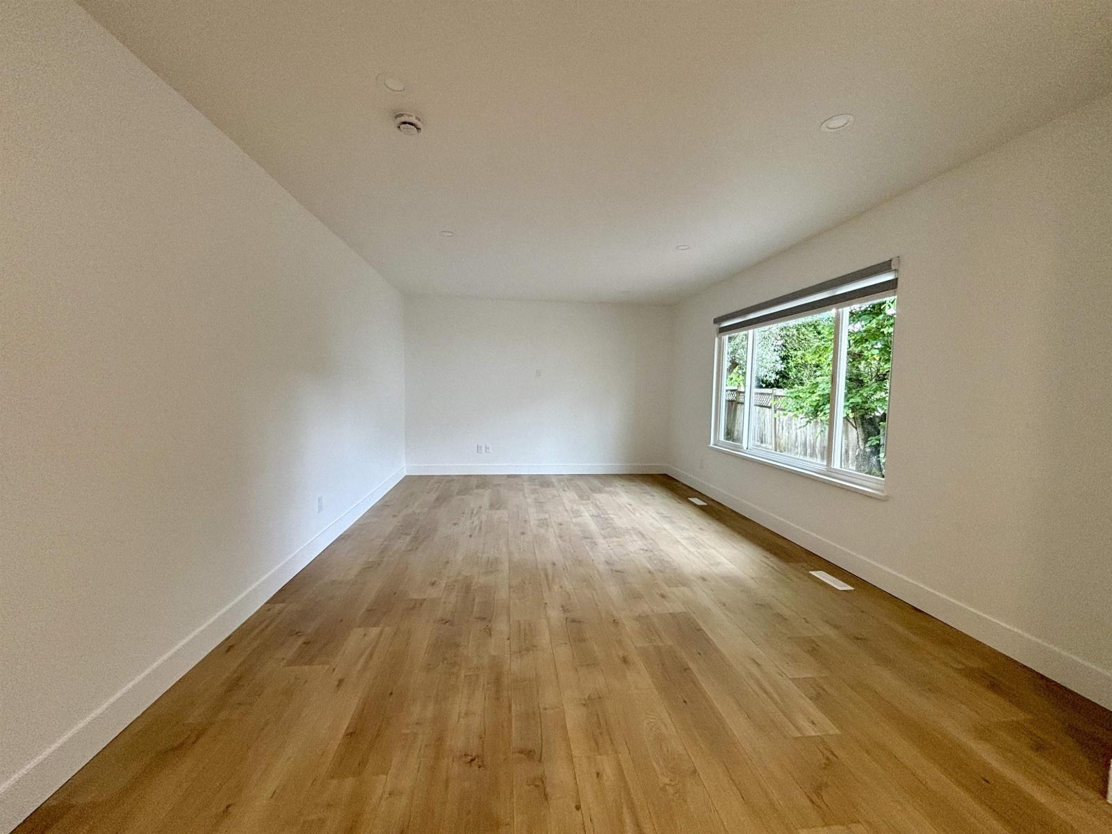 A room with wooden flooring and a window.