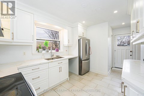A kitchen with white cabinets and a black stove top oven.