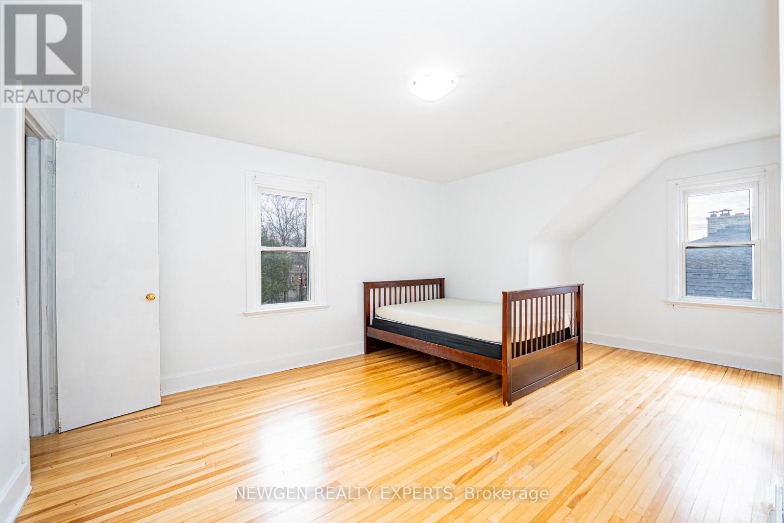A bedroom with a bed, a window, and a door.