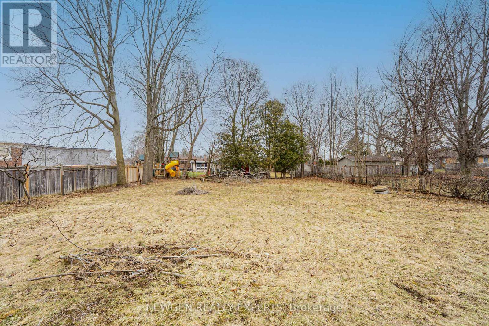 A backyard with a fence and trees.
