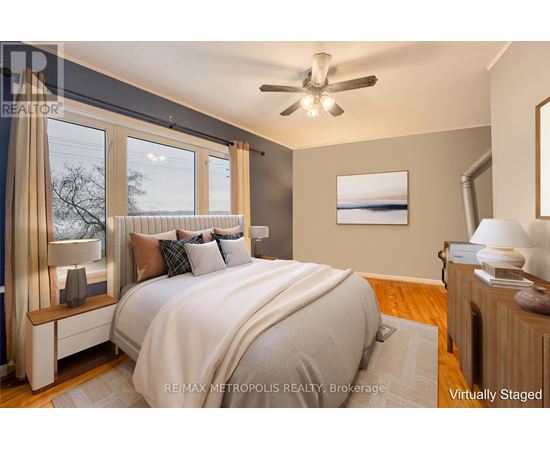 A bedroom with a large bed and a ceiling fan.