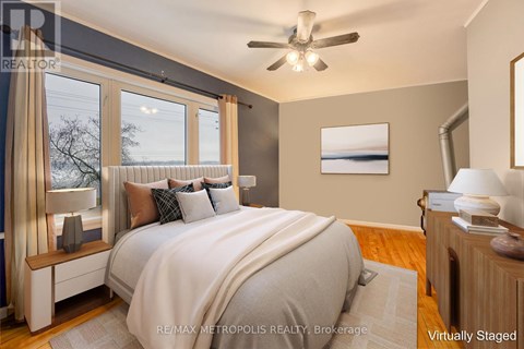 A bedroom with a large bed and a ceiling fan.