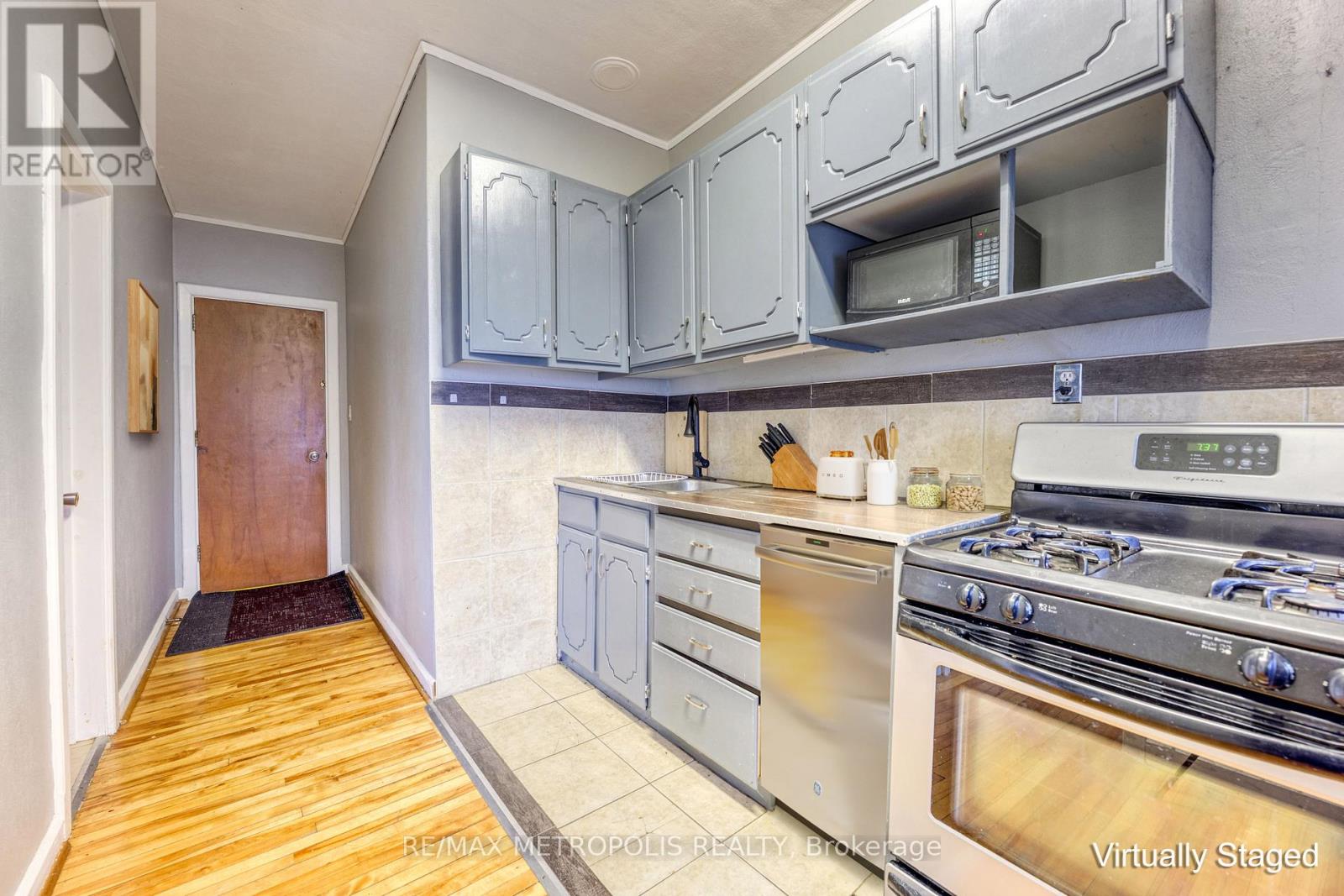 A kitchen with a stove top oven and cabinets above it.