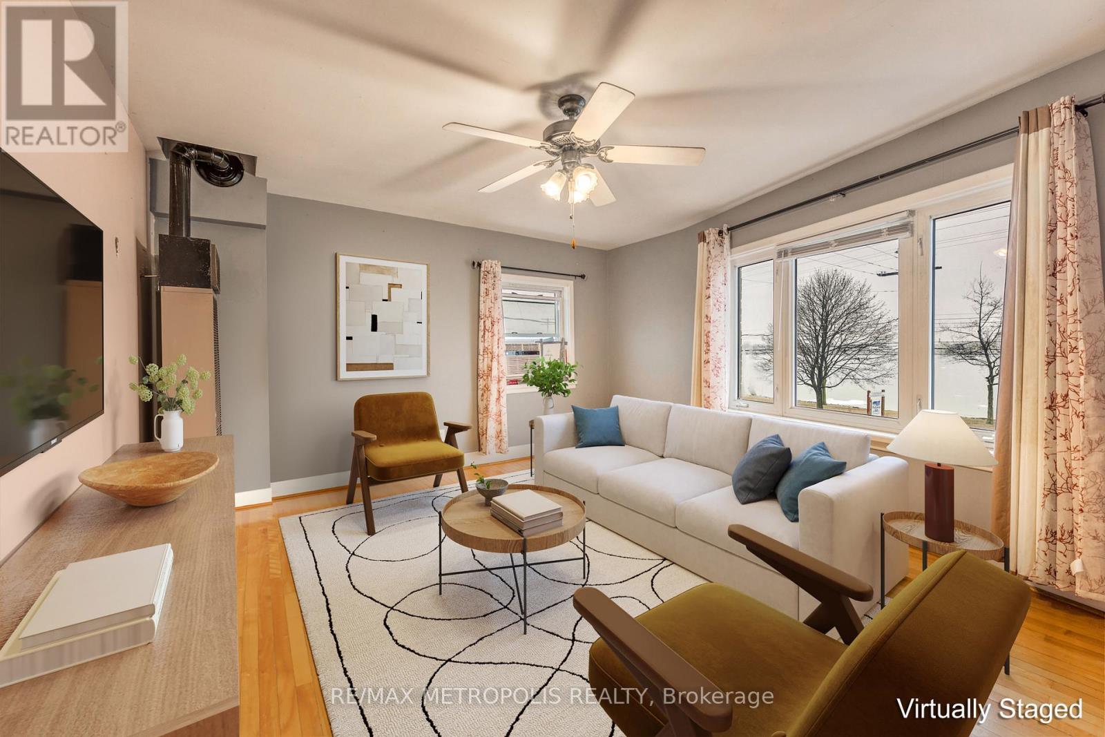 A living room with a white couch, a brown chair, and a rug.