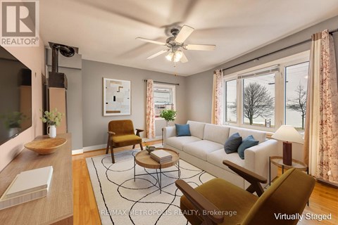A living room with a white couch, a brown chair, and a rug.
