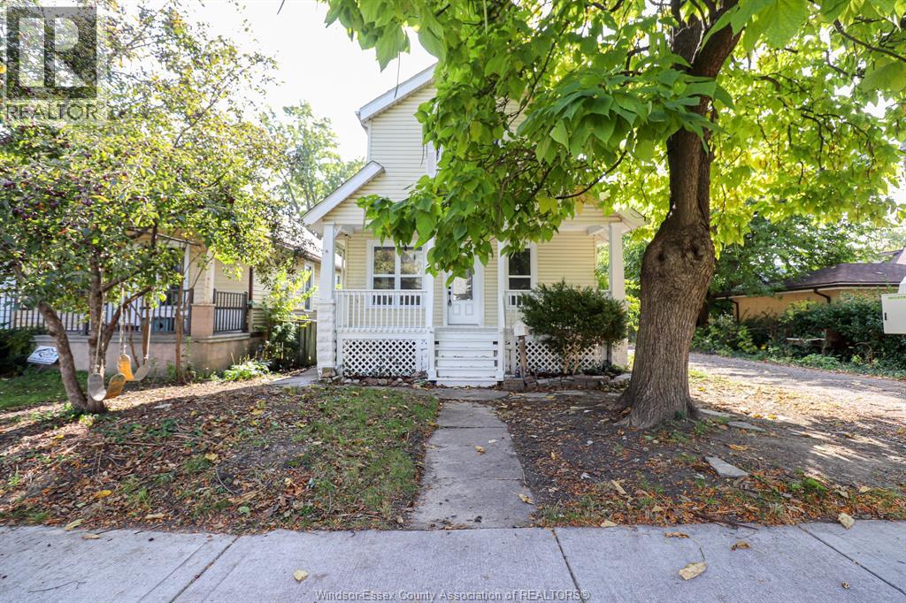A house with a white fence and a tree in front.
