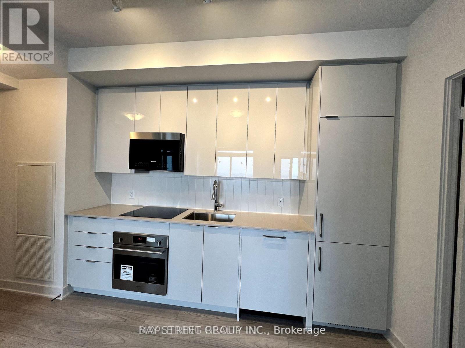 A modern kitchen with white cabinets and a stainless steel oven.