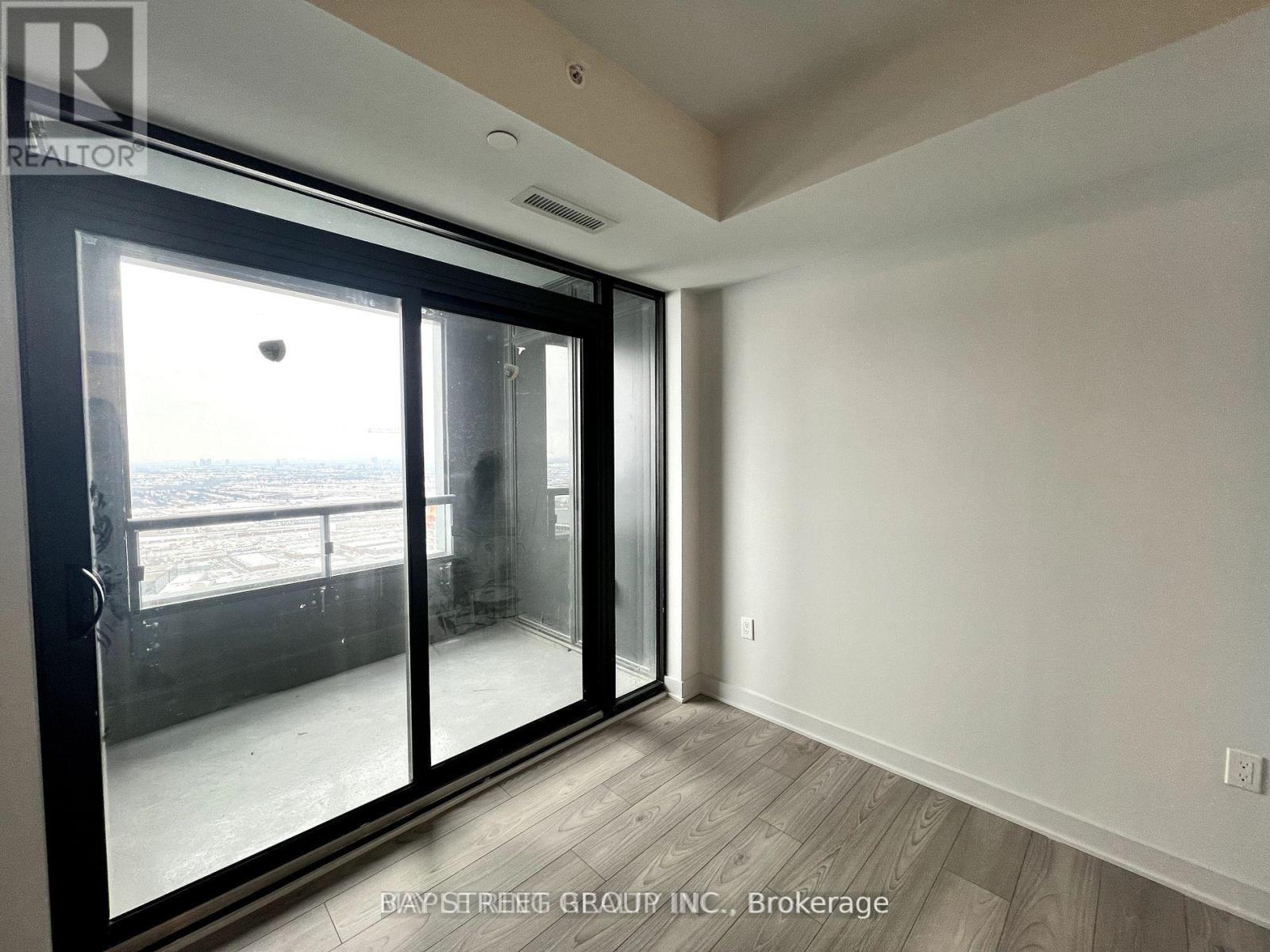 A room with a sliding glass door leading to a balcony.