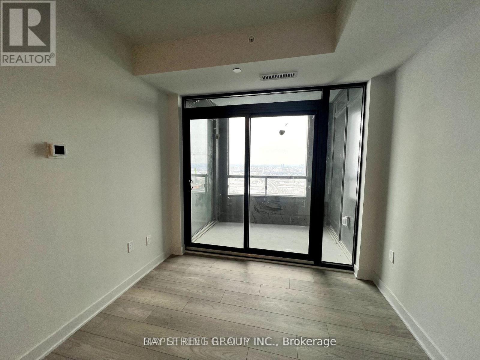 A room with a sliding glass door leading to a balcony.