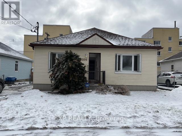 A house with a brown roof and a small front yard.