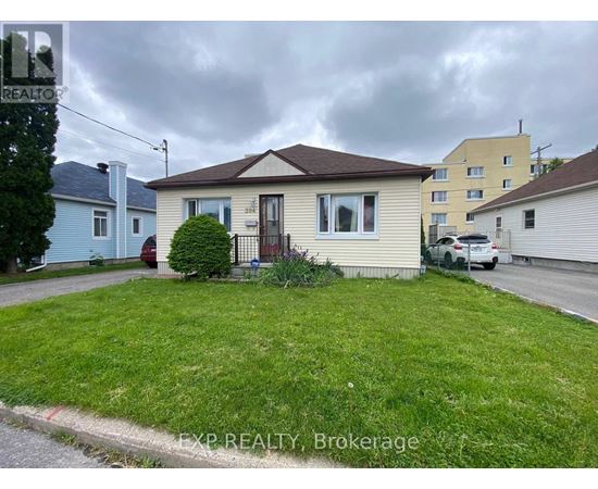 A house with a brown roof and a small front yard.