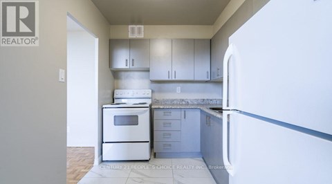 A kitchen with white appliances and cabinets is shown.