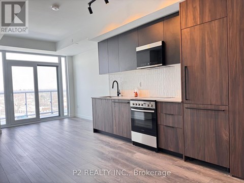 A modern kitchen with wooden cabinets and a stainless steel oven.
