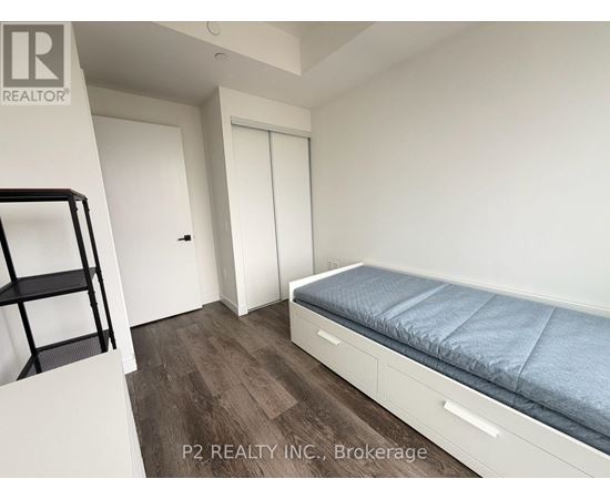 A bedroom with a bed, a chair, and a desk.