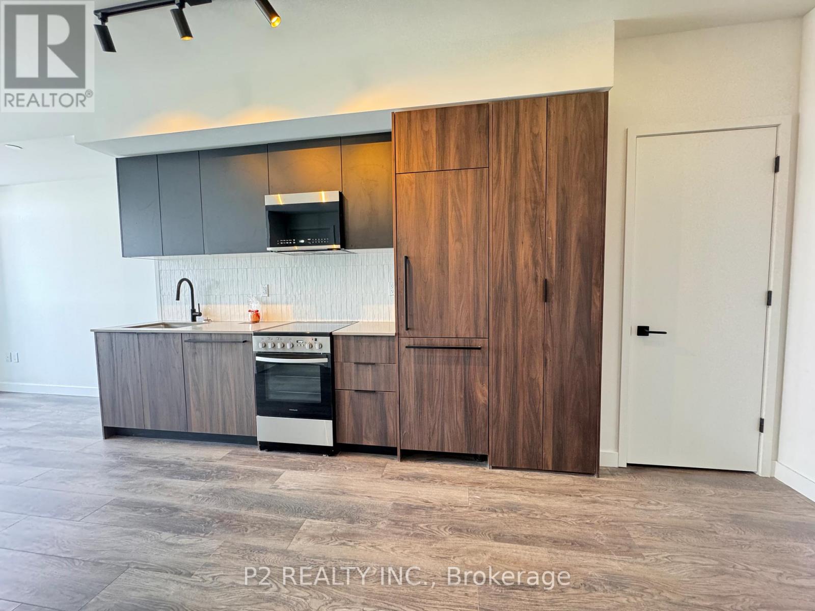 A modern kitchen with a wooden cabinet and a stove top oven.