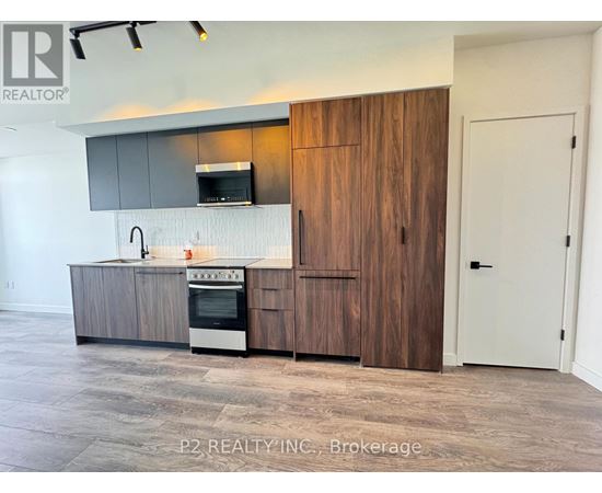 A modern kitchen with a wooden cabinet and a stove top oven.