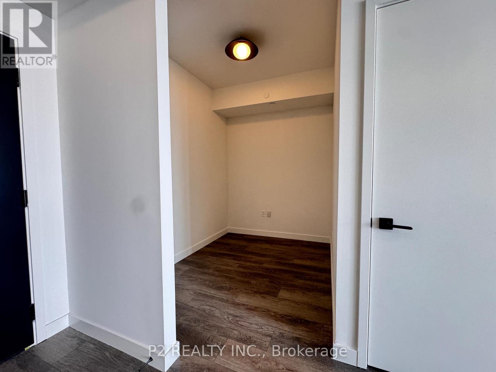 A room with a door and a light on the ceiling.