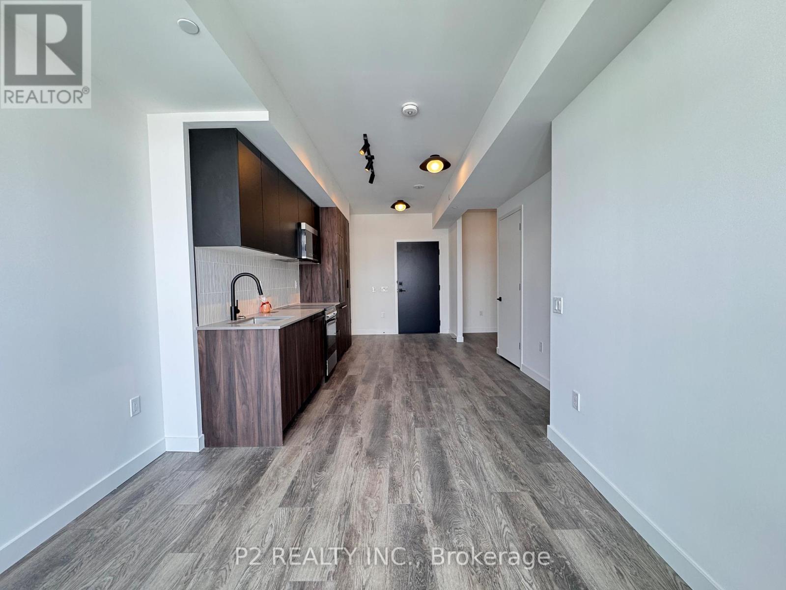 A spacious room with a bar area and a door at the end.