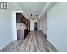 A spacious room with a bar area and a door at the end.
