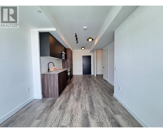 A spacious room with a bar area and a door at the end.