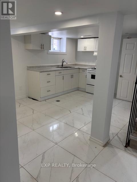 A white kitchen with a sink and cabinets.