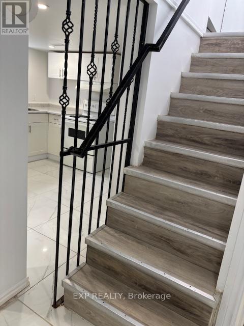 A staircase with a black metal railing and wooden steps.