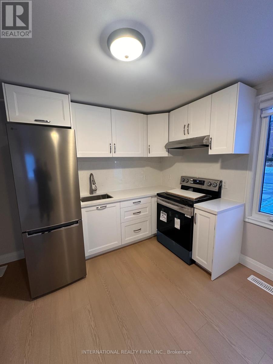 A kitchen with white cabinets and a stainless steel refrigerator.