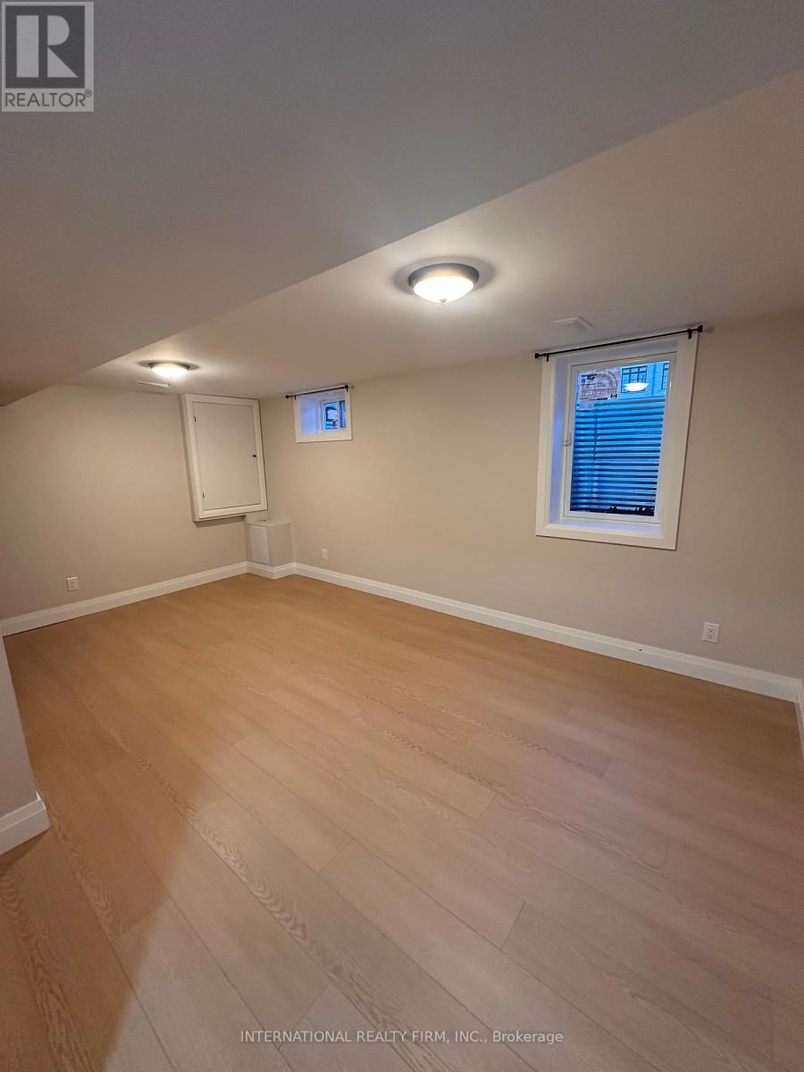 A room with wooden flooring and a window with blinds.