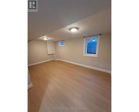 A room with wooden flooring and a window with blinds.