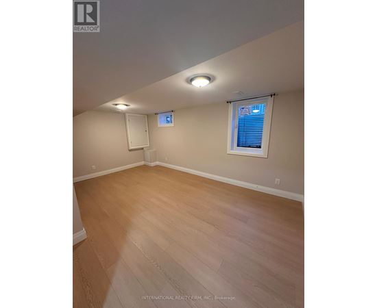 A room with wooden flooring and a window with blinds.