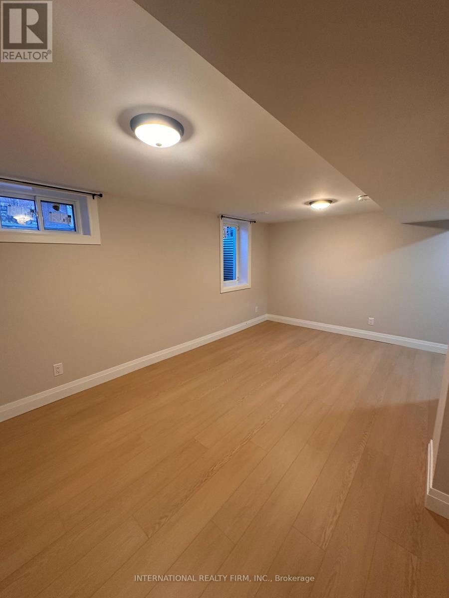 A room with wooden flooring and a window with blinds.