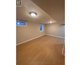 A room with wooden flooring and a window with blinds.