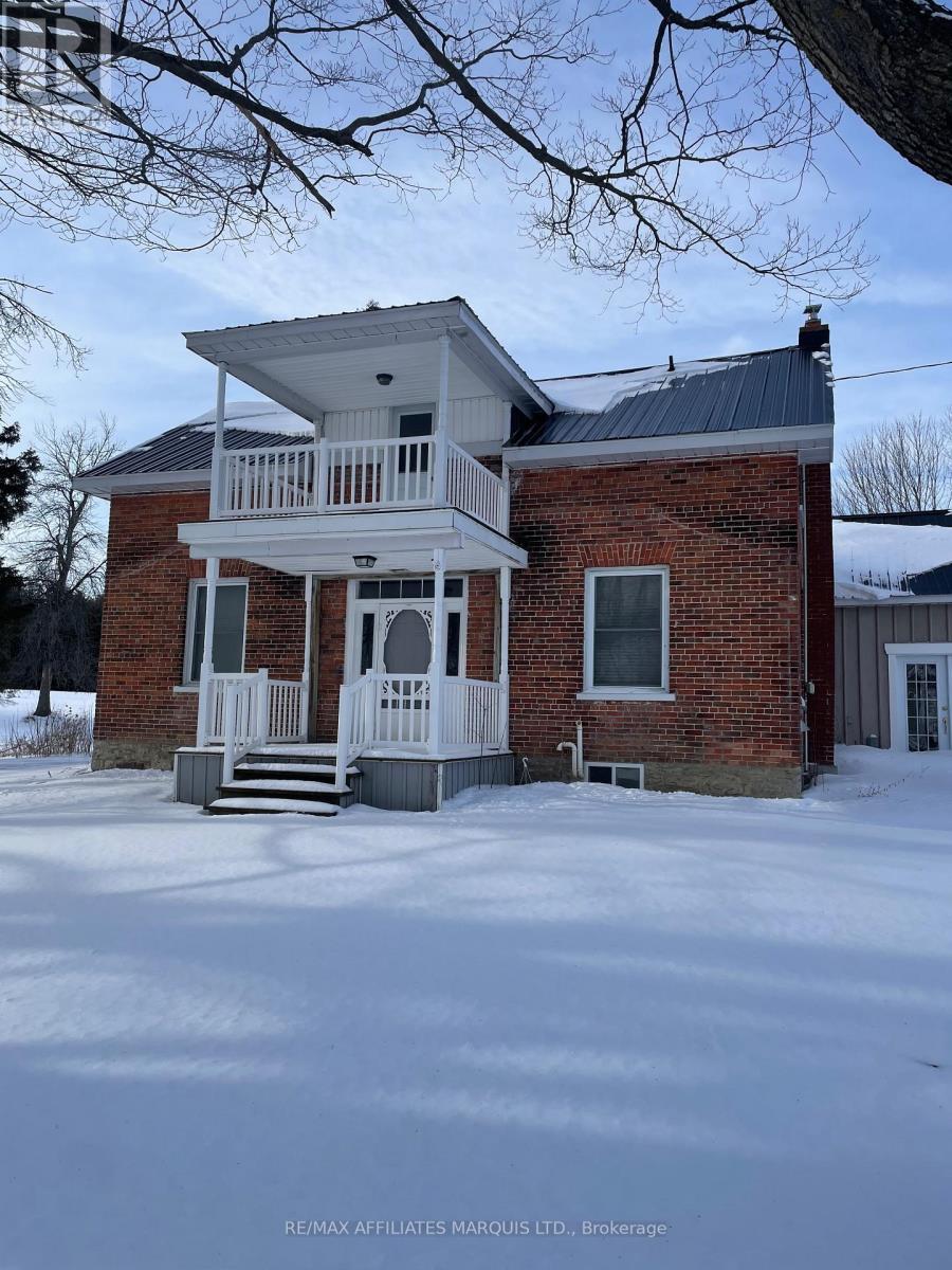 A house with a white porch and a brick exterior is shown in the image.
