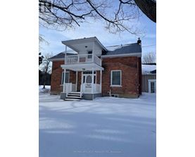 A house with a white porch and a brick exterior is shown in the image.