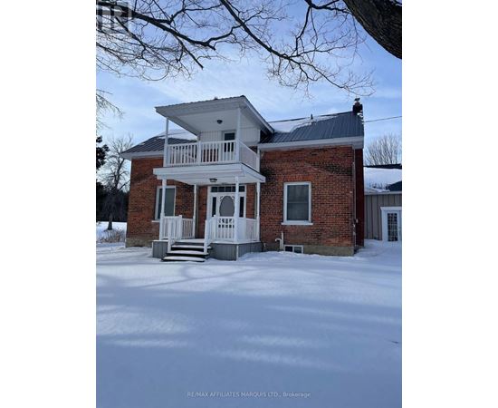 A house with a white porch and a brick exterior is shown in the image.