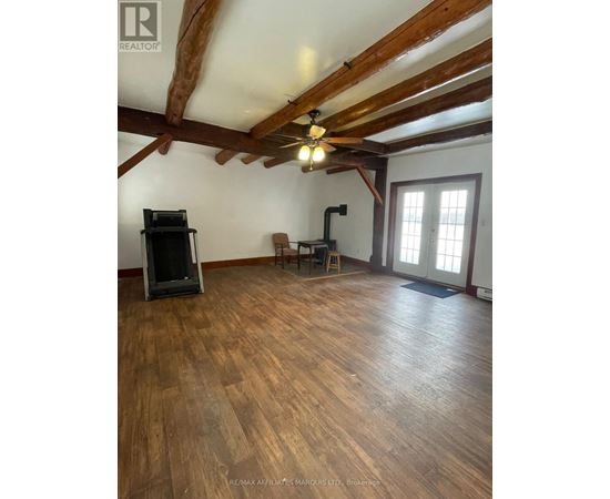 A room with wooden floors and a ceiling fan.