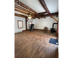 A room with wooden floors and a ceiling fan.
