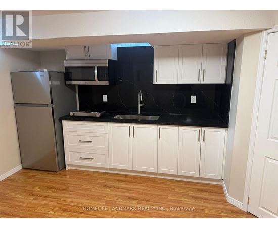 A kitchen with white cabinets and a black countertop.