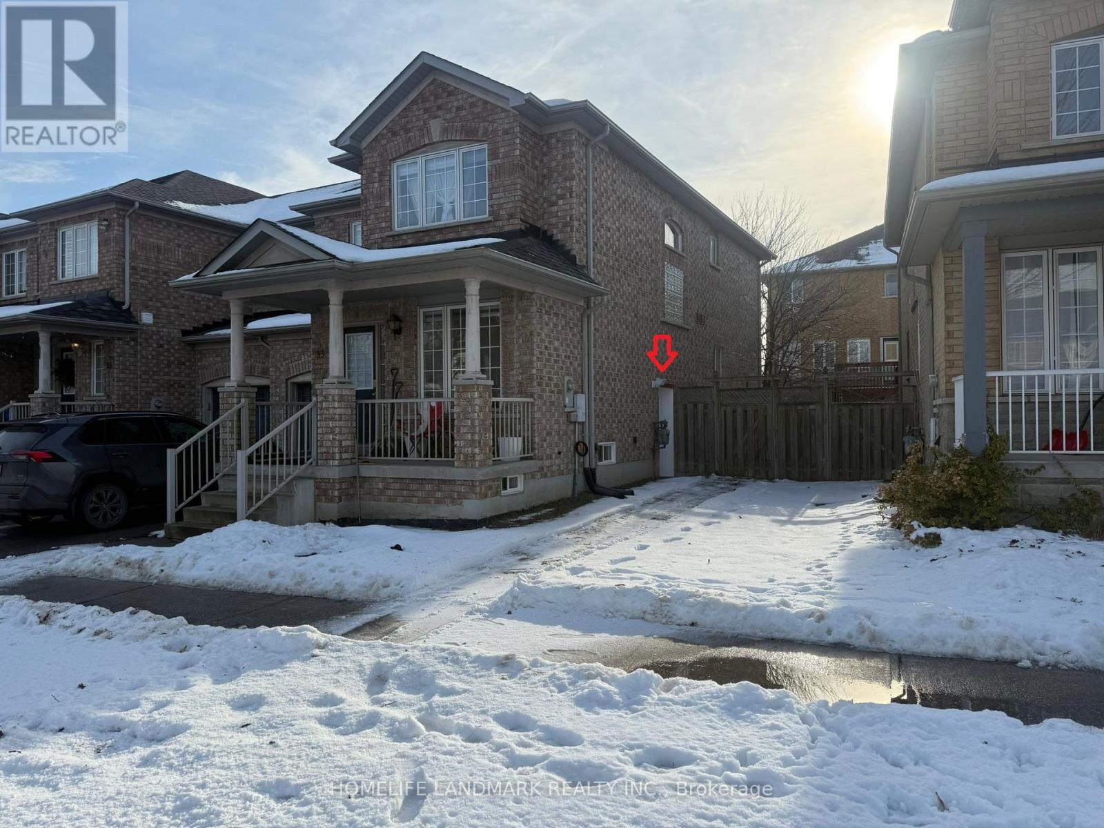 A house with a snow-covered ground in front of it.