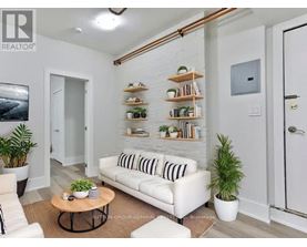 A living room with a white couch, a coffee table, and a plant.