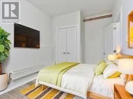A bedroom with a bed, a plant, and a television.